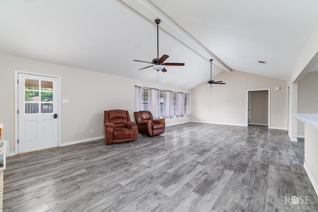 unfurnished room with visible vents, wood finished floors, baseboards, lofted ceiling with beams, and a ceiling fan