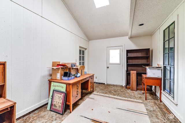 interior space with a textured ceiling and lofted ceiling
