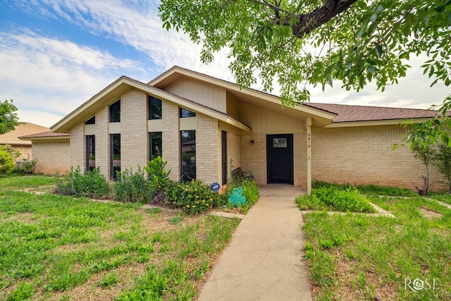 mid-century modern home with brick siding