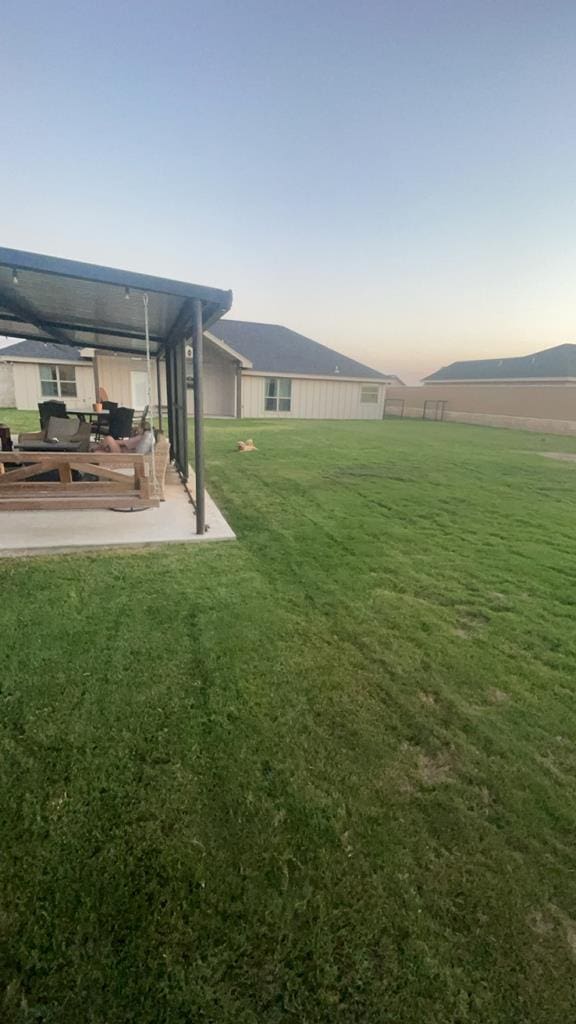 yard at dusk with a patio area