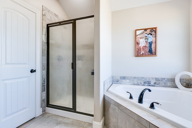 bathroom with a stall shower, a garden tub, and tile patterned floors