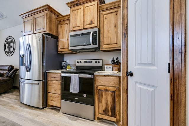 kitchen featuring light countertops, appliances with stainless steel finishes, and light wood-style floors