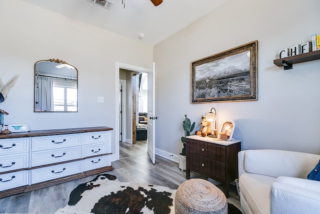 living area featuring visible vents, dark wood finished floors, baseboards, and ceiling fan