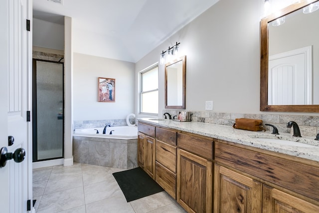 bathroom featuring a sink, double vanity, a garden tub, and tile patterned floors