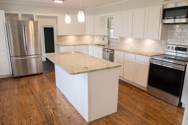 kitchen featuring sink, a center island, hanging light fixtures, stainless steel appliances, and white cabinets