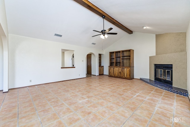 unfurnished living room featuring light tile patterned floors, arched walkways, a large fireplace, visible vents, and beam ceiling