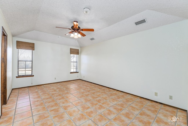 unfurnished room with lofted ceiling, ceiling fan, visible vents, and a textured ceiling