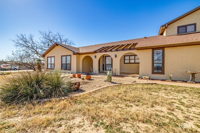 view of front of property with roof with shingles and stucco siding