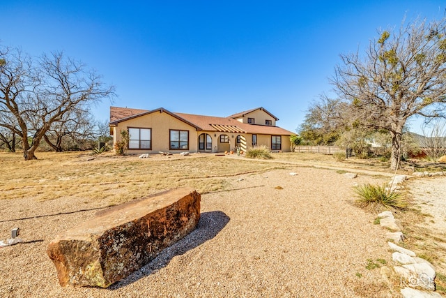 view of front of house featuring fence and stucco siding