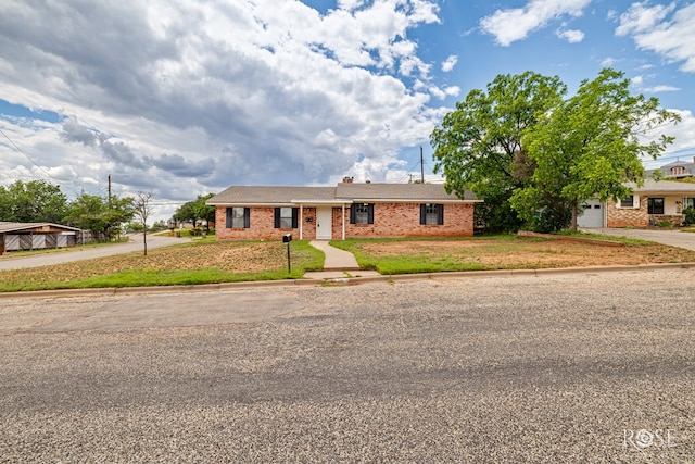 2109 Dartmouth Dr, San Angelo, TX 76904 - view of front of home with driveway, brick siding, and a front lawn