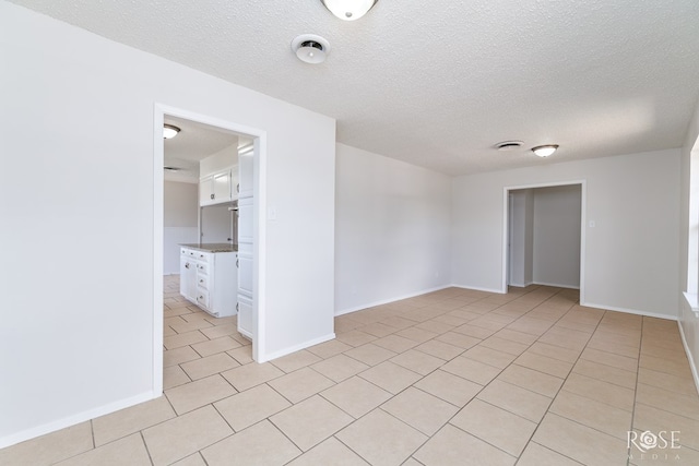 2109 Dartmouth Dr, San Angelo, TX 76904 - spare room with baseboards, light tile patterned floors, and a textured ceiling
