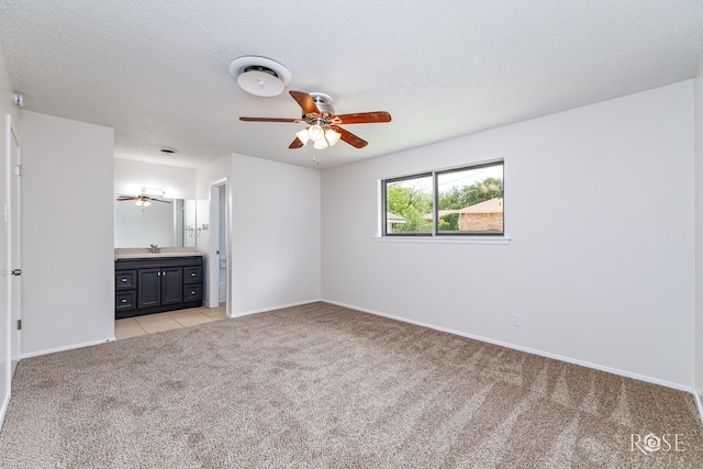 2109 Dartmouth Dr, San Angelo, TX 76904 - unfurnished bedroom featuring light colored carpet, a sink, baseboards, connected bathroom, and a textured ceiling