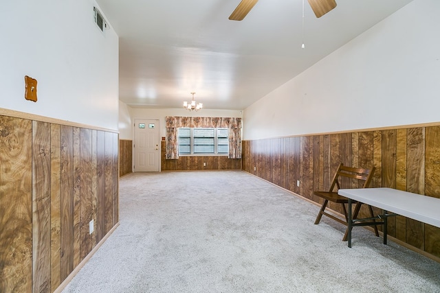 2650 Rice Ave, San Angelo, TX 76904 - unfurnished living room with wainscoting, a chandelier, wood walls, carpet floors, and ceiling fan