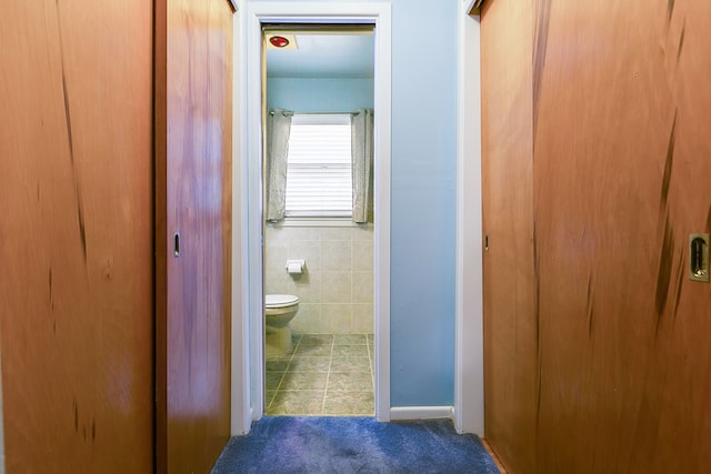 2650 Rice Ave, San Angelo, TX 76904 - bathroom with toilet, tile walls, and tile patterned flooring
