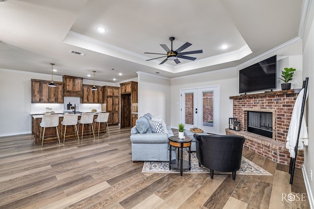 5034 Scarlet Oak Ln, San Angelo, TX 76904 - living room with a raised ceiling, light wood finished floors, crown molding, ceiling fan, and baseboards