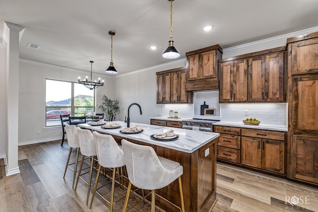 5034 Scarlet Oak Ln, San Angelo, TX 76904 - kitchen with a sink, a breakfast bar, backsplash, crown molding, and a center island with sink