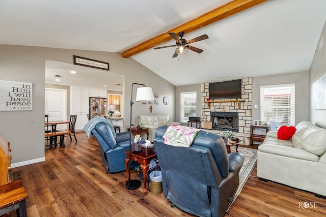 living room featuring ceiling fan, a stone fireplace, vaulted ceiling with beams, and dark hardwood / wood-style flooring