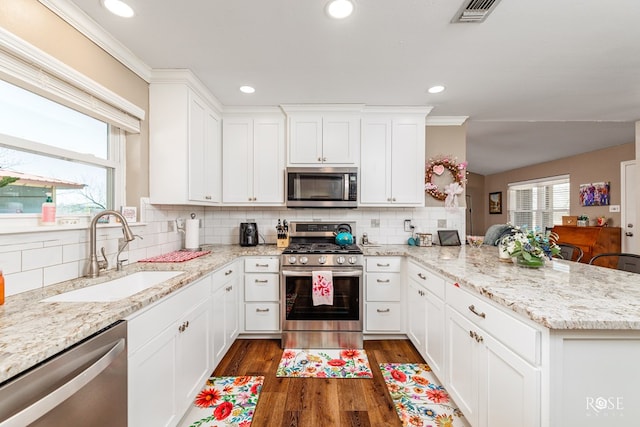 kitchen featuring sink, white cabinetry, stainless steel appliances, light stone countertops, and dark hardwood / wood-style flooring