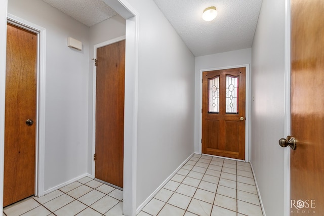 5821 Davenport Dr, San Angelo, TX 76901 - doorway to outside with a textured ceiling, baseboards, and light tile patterned floors