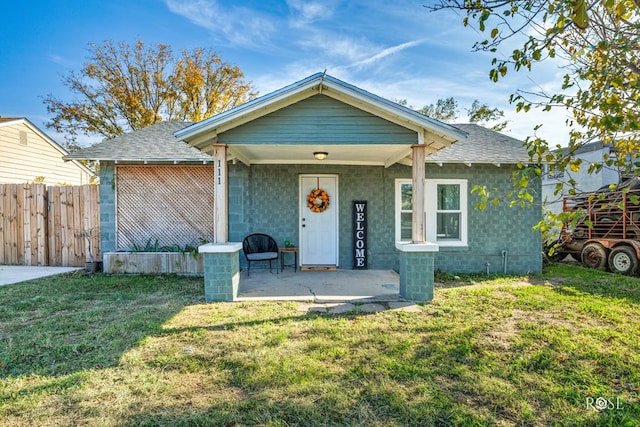 bungalow-style house featuring a front lawn and a patio