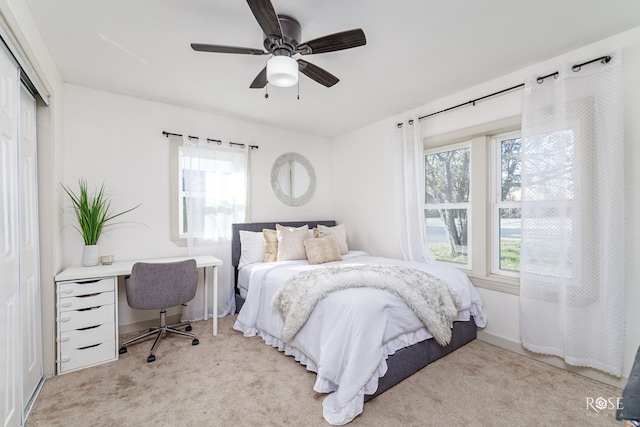 bedroom featuring light carpet, ceiling fan, and a closet