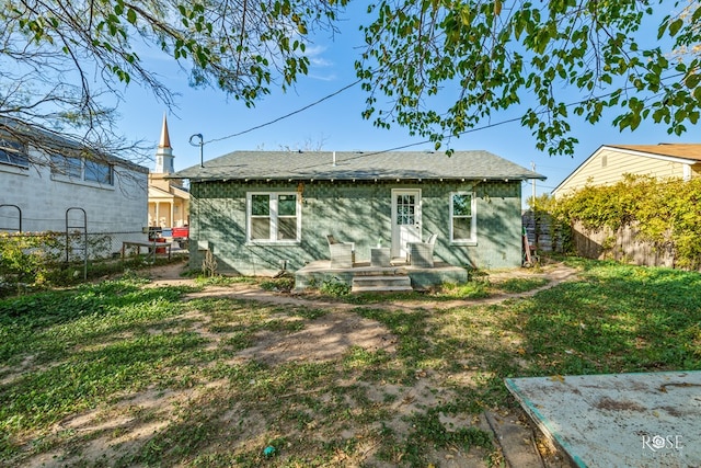 back of property featuring a lawn