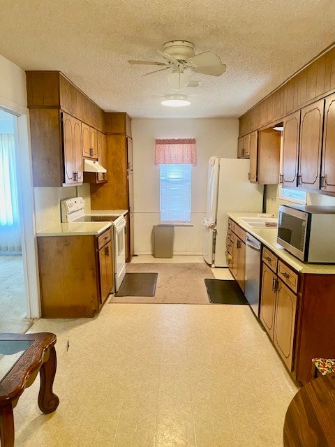 8882 Fm 765, San Angelo, TX 76905 - kitchen with appliances with stainless steel finishes, a ceiling fan, light countertops, under cabinet range hood, and light floors