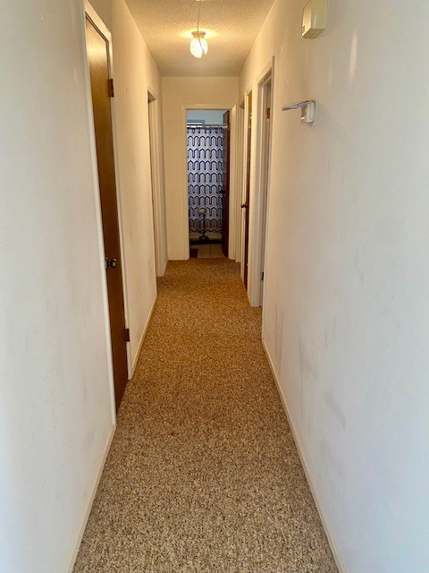 8882 Fm 765, San Angelo, TX 76905 - hall with a textured ceiling and baseboards