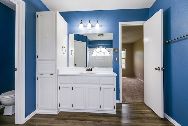 1605 Amberton Pkwy, San Angelo, TX 76901 - bathroom featuring toilet, wood finished floors, vanity, and baseboards