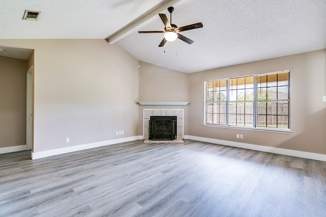 1605 Amberton Pkwy, San Angelo, TX 76901 - unfurnished living room featuring wood finished floors, ceiling fan, a fireplace, a textured ceiling, and baseboards