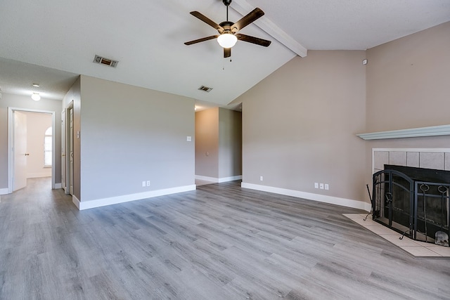 1605 Amberton Pkwy, San Angelo, TX 76901 - unfurnished living room with a ceiling fan, a tiled fireplace, beamed ceiling, wood finished floors, and baseboards
