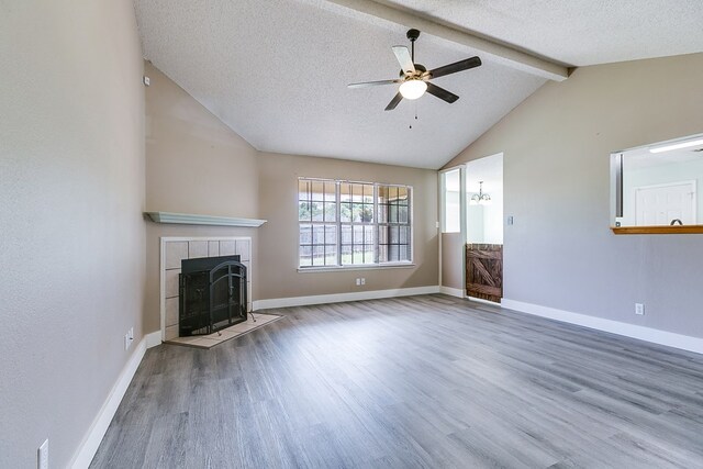 1605 Amberton Pkwy, San Angelo, TX 76901 - unfurnished living room featuring wood finished floors, a ceiling fan, a tile fireplace, a textured ceiling, and baseboards