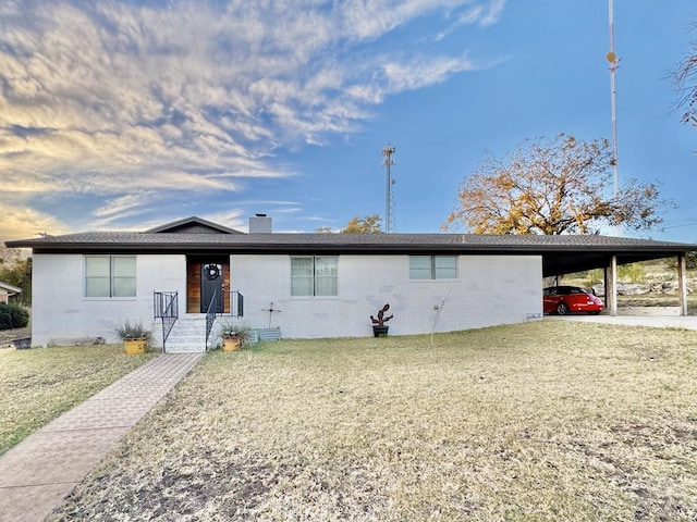 ranch-style house featuring a carport and a front lawn