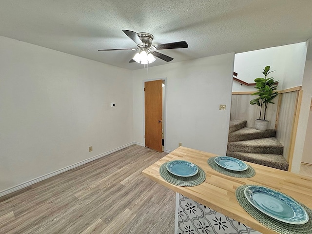 1036 Glenna Dr, San Angelo, TX 76901 - dining space featuring stairway, light wood-style flooring, a textured ceiling, and a ceiling fan