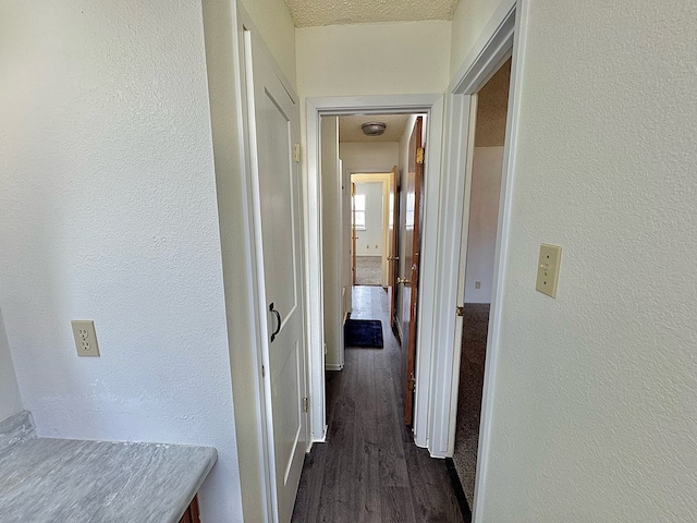 1036 Glenna Dr, San Angelo, TX 76901 - hallway with dark wood-type flooring, a textured wall, and a textured ceiling