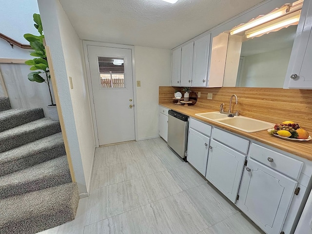 1036 Glenna Dr, San Angelo, TX 76901 - kitchen featuring dishwasher, a textured ceiling, tasteful backsplash, and white cabinets