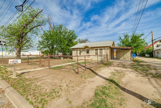 ranch-style home with metal roof and fence