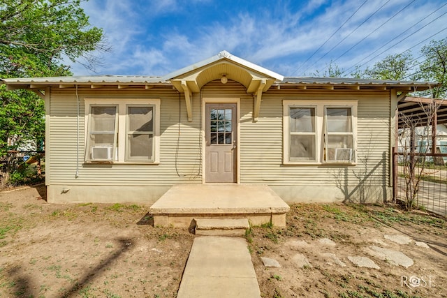 view of front of house featuring fence and metal roof
