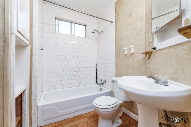 bathroom featuring toilet, shower / bath combination, and wood finished floors