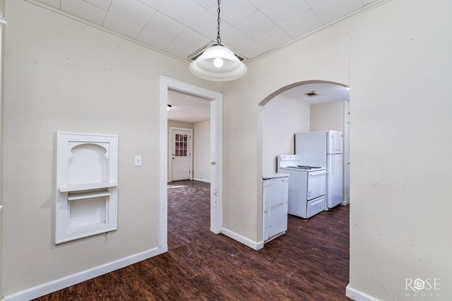 interior space with baseboards, arched walkways, white appliances, and dark wood-type flooring