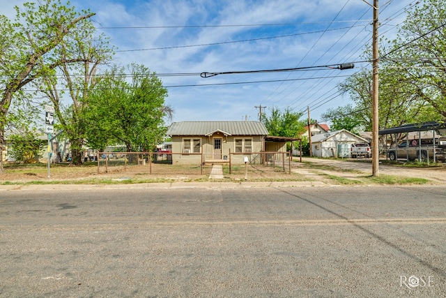 view of front of property with metal roof and a fenced front yard