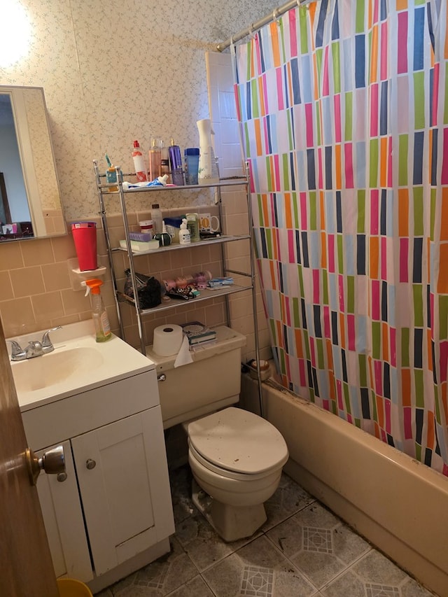 233 Robin Hood Trl, San Angelo, TX 76901 - full bathroom featuring tile walls, vanity, shower / tub combo with curtain, toilet, and tile patterned flooring