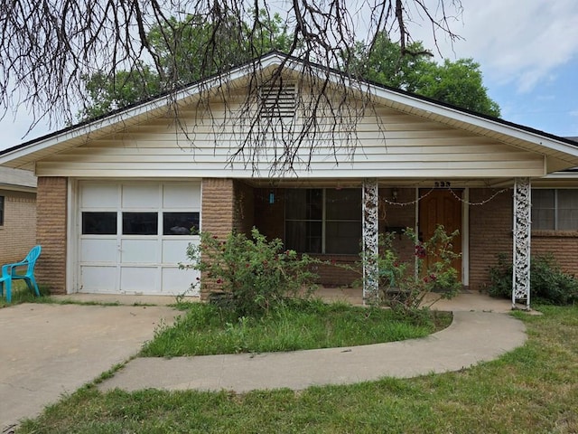 233 Robin Hood Trl, San Angelo, TX 76901 - view of front facade with brick siding, concrete driveway, and a garage