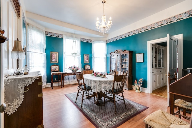 dining space with a notable chandelier and light hardwood / wood-style flooring