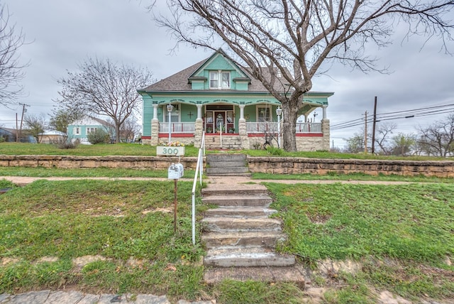 victorian house featuring a front yard and a porch