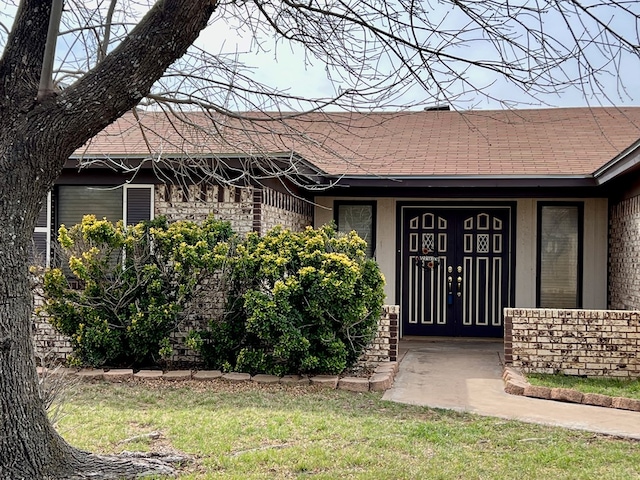 doorway to property featuring a shingled roof and stucco siding