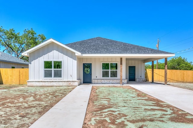 2122 Deaton St, San Angelo, TX 76903 - view of front of home with roof with shingles, board and batten siding, fence, and an attached carport