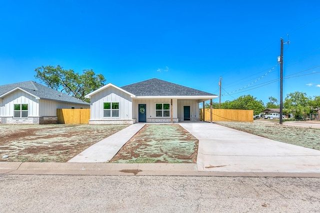 2122 Deaton St, San Angelo, TX 76903 - view of front of home with board and batten siding, fence, driveway, and roof with shingles