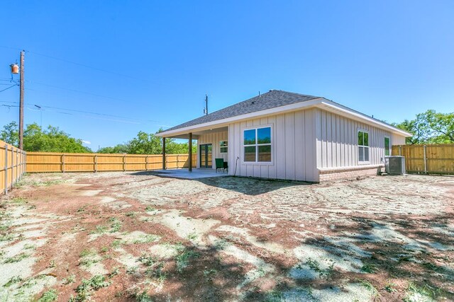 2122 Deaton St, San Angelo, TX 76903 - rear view of house with board and batten siding, a fenced backyard, roof with shingles, a patio area, and cooling unit