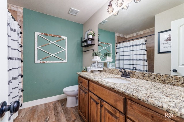 full bathroom with visible vents, toilet, wood finished floors, and vanity